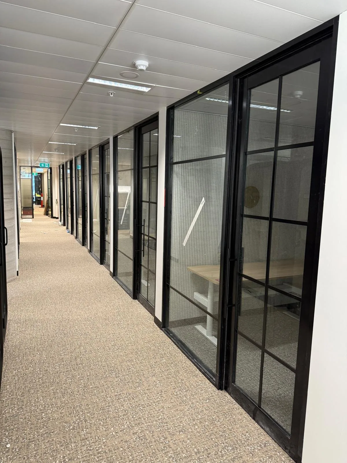Corridor of black framed glazed offices at Clyde and Co